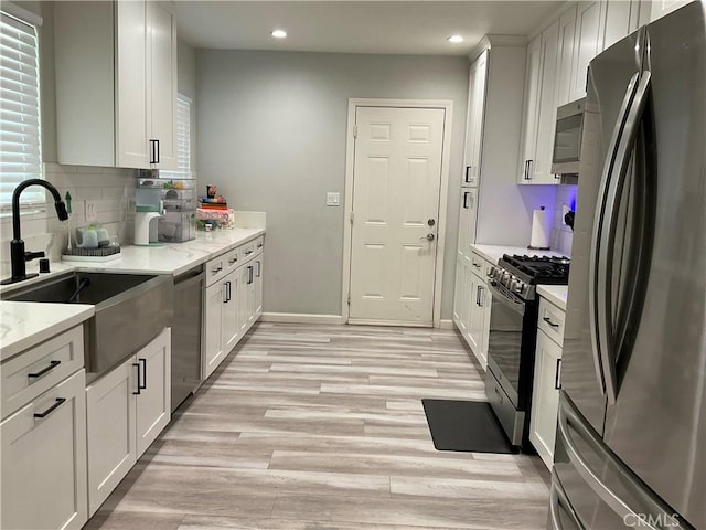 114 S Acacia Ave, Rialto, CA 92376 - kitchen featuring appliances with stainless steel finishes, recessed lighting, white cabinets, light wood-type flooring, and backsplash