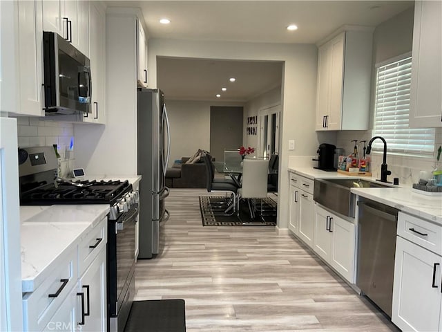 114 S Acacia Ave, Rialto, CA 92376 - kitchen with stainless steel appliances, recessed lighting, white cabinetry, tasteful backsplash, and light wood finished floors