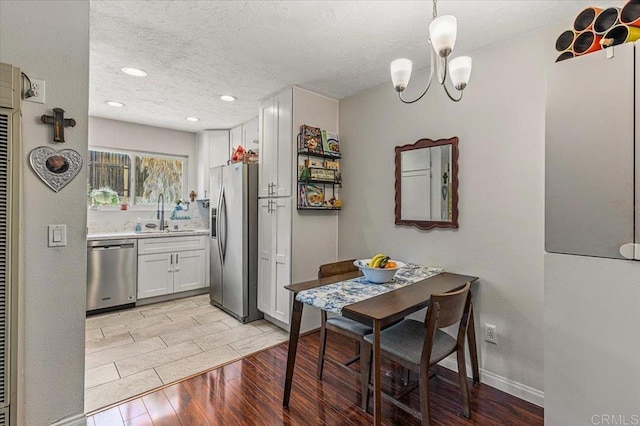 10214 Michala Pl, Santee, CA 92071 - kitchen with appliances with stainless steel finishes, light wood-type flooring, a textured ceiling, a sink, and light countertops