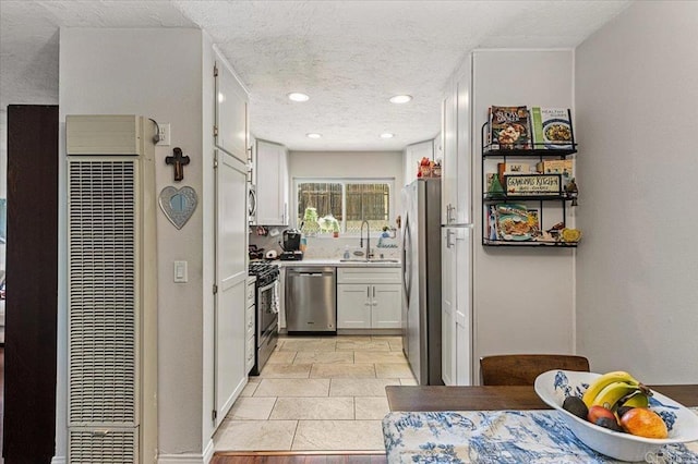 10214 Michala Pl, Santee, CA 92071 - kitchen with stainless steel appliances, a heating unit, white cabinetry, a sink, and light countertops