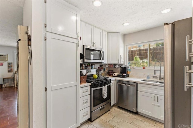 10214 Michala Pl, Santee, CA 92071 - kitchen featuring appliances with stainless steel finishes, a textured ceiling, a sink, light countertops, and white cabinets