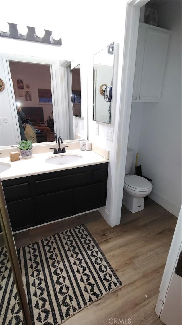 15343 Oakham Ct, Moreno Valley, CA 92551 - ensuite bathroom featuring double vanity, wood finished floors, toilet, and baseboards