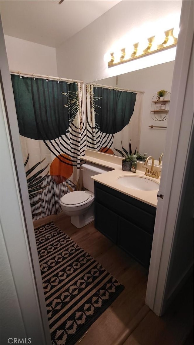 15343 Oakham Ct, Moreno Valley, CA 92551 - full bathroom with wood finished floors, vanity, toilet, and a shower with shower curtain