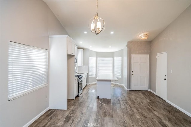14079 El Camino Pl, Fontana, CA 92337 - kitchen with stainless steel gas stove, a chandelier, white cabinetry, wood finished floors, and light countertops