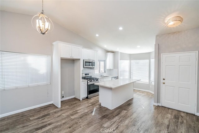 14079 El Camino Pl, Fontana, CA 92337 - kitchen with appliances with stainless steel finishes, white cabinets, a sink, a kitchen island, and wood finished floors
