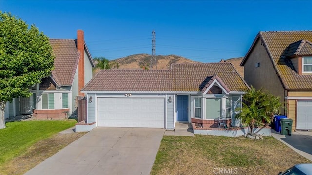 14079 El Camino Pl, Fontana, CA 92337 - view of front of home featuring a tile roof, a garage, driveway, and a front yard