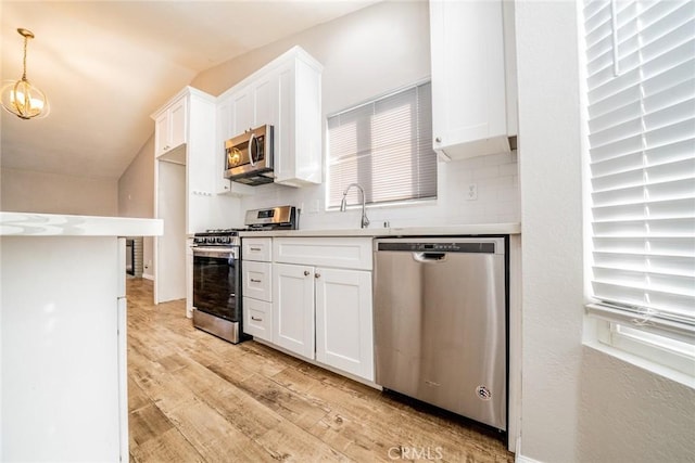 14079 El Camino Pl, Fontana, CA 92337 - kitchen with stainless steel appliances, light wood-style flooring, white cabinetry, a sink, and backsplash