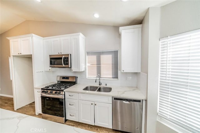 14079 El Camino Pl, Fontana, CA 92337 - kitchen featuring stainless steel appliances, a sink, backsplash, white cabinetry, and vaulted ceiling