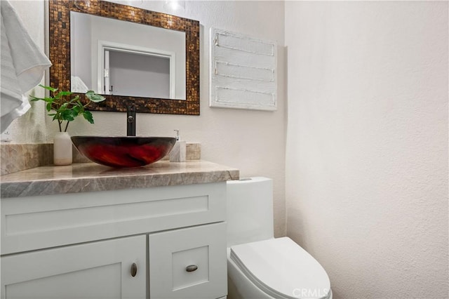 61 Bridgeport, Irvine, CA 92620 - half bathroom with vanity, toilet, and a textured wall