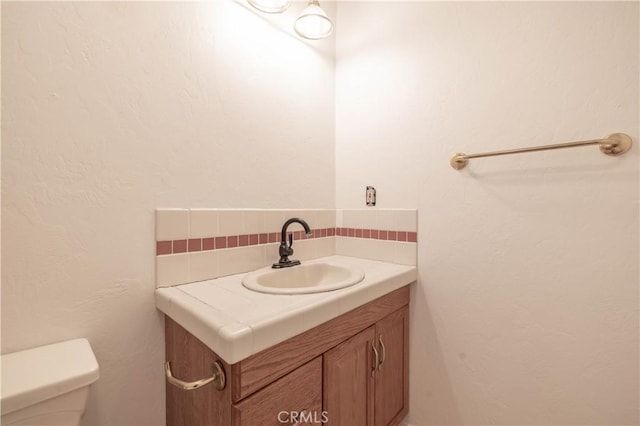 600 Moreno Ln, Sugarloaf, CA 92386 - bathroom featuring vanity, backsplash, and toilet