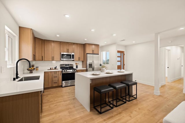 101 Coolwater Dr, San Diego, CA 92114 - kitchen with stainless steel appliances, a sink, a breakfast bar area, a center island, and light countertops