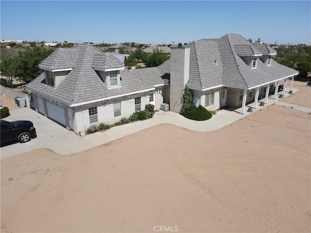 8250 Cataba Rd, Oak Hills, CA 92344 - view of front of property with concrete driveway, an attached garage, stucco siding, and a chimney