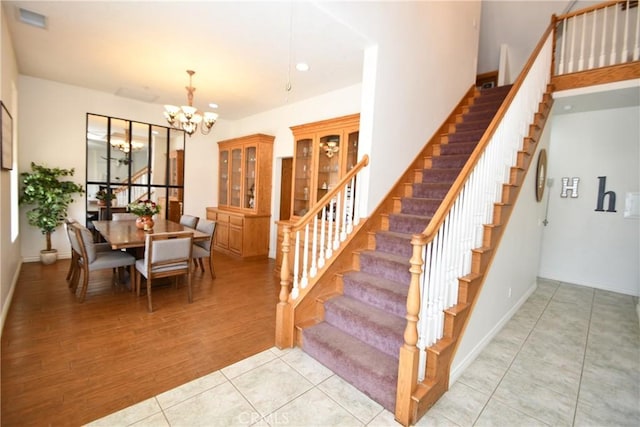 8250 Cataba Rd, Oak Hills, CA 92344 - staircase with a chandelier, tile patterned flooring, baseboards, and recessed lighting