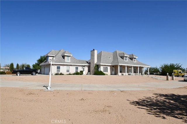 8250 Cataba Rd, Oak Hills, CA 92344 - back of property featuring a chimney, an attached garage, and concrete driveway
