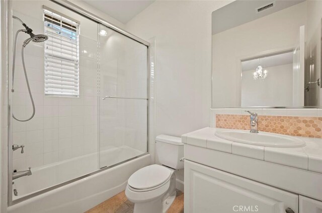 21 Land Bird, Irvine, CA 92618 - full bathroom with toilet, vanity, bath / shower combo with glass door, decorative backsplash, and a chandelier