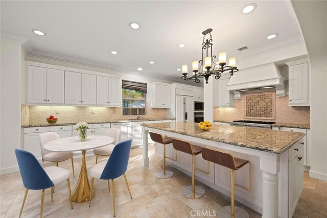 21 Land Bird, Irvine, CA 92618 - kitchen featuring ornamental molding, built in appliances, a center island, decorative backsplash, and white cabinetry