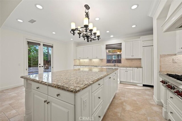 21 Land Bird, Irvine, CA 92618 - kitchen featuring a sink, a center island, decorative backsplash, a chandelier, and white cabinetry