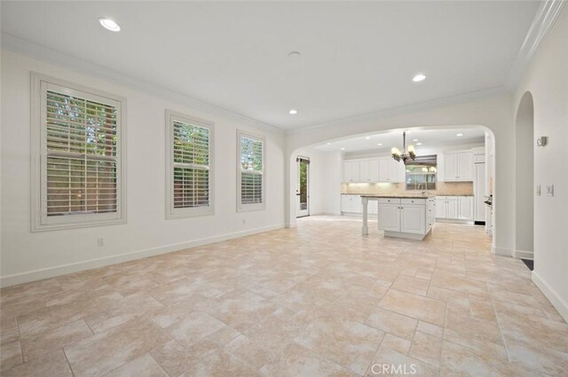 21 Land Bird, Irvine, CA 92618 - unfurnished living room with arched walkways, a chandelier, crown molding, healthy amount of natural light, and recessed lighting
