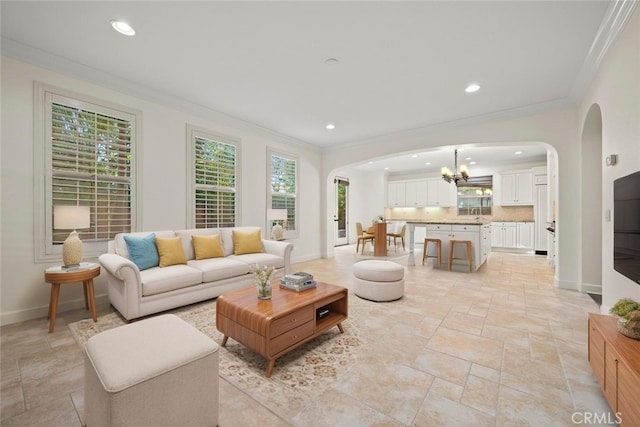 21 Land Bird, Irvine, CA 92618 - living area featuring arched walkways, crown molding, stone tile flooring, a chandelier, and recessed lighting