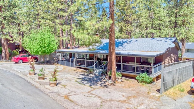 5726 Lodgepole Dr, Wrightwood, CA 92397 - view of front of property featuring a porch, view of scattered trees, and a shingled roof