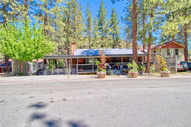 5726 Lodgepole Dr, Wrightwood, CA 92397 - view of front of house with a carport, a chimney, and a porch