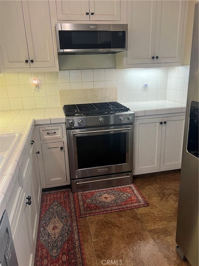 5726 Lodgepole Dr, Wrightwood, CA 92397 - kitchen featuring appliances with stainless steel finishes, tile counters, and white cabinets