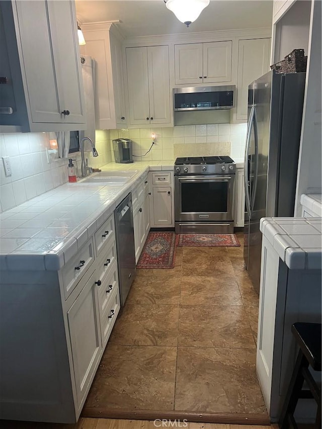 5726 Lodgepole Dr, Wrightwood, CA 92397 - kitchen featuring appliances with stainless steel finishes, tile countertops, ventilation hood, a sink, and tasteful backsplash