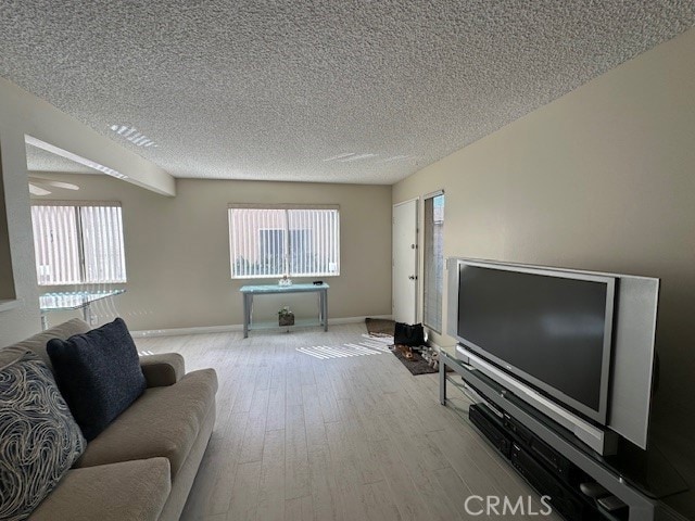 2070 Avenida Placida Unit 3, Simi Valley, CA 93063 - living area with plenty of natural light, wood finished floors, a textured ceiling, and baseboards