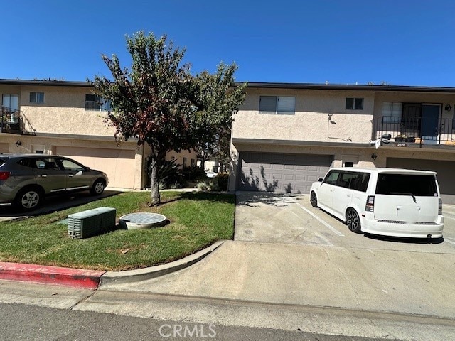 2070 Avenida Placida Unit 3, Simi Valley, CA 93063 - multi unit property featuring driveway, a garage, stucco siding, a front yard, and a balcony