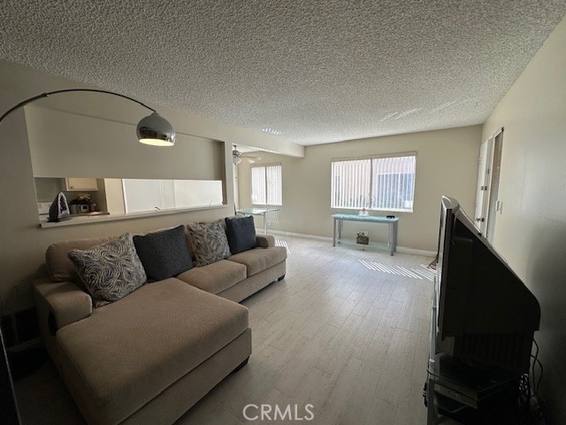 2070 Avenida Placida Unit 3, Simi Valley, CA 93063 - living area with a textured ceiling, wood finished floors, and baseboards