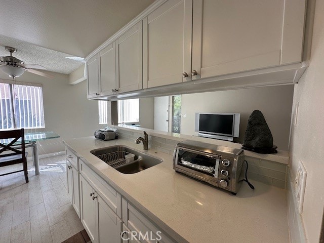 2070 Avenida Placida Unit 3, Simi Valley, CA 93063 - kitchen featuring a sink, white cabinetry, plenty of natural light, and a textured ceiling