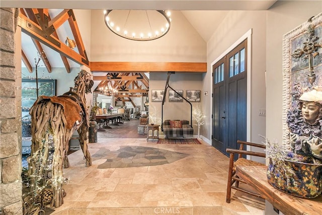 923 Lake Edge Way, Lake Arrowhead, CA 92352 - entrance foyer featuring a chandelier, stone tile flooring, high vaulted ceiling, and beam ceiling