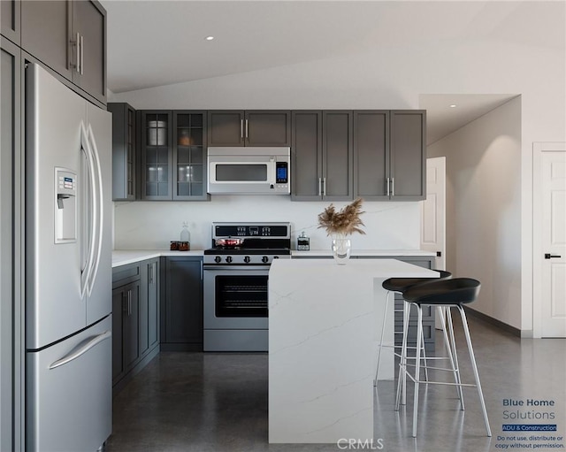 11725 Lagartijo Dr, Apple Valley, CA 92308 - kitchen featuring fridge with ice dispenser, white microwave, stainless steel range with gas stovetop, gray cabinets, and lofted ceiling