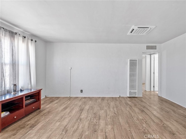 1040 Flora St, Barstow, CA 92311 - empty room with a heating unit and wood finished floors