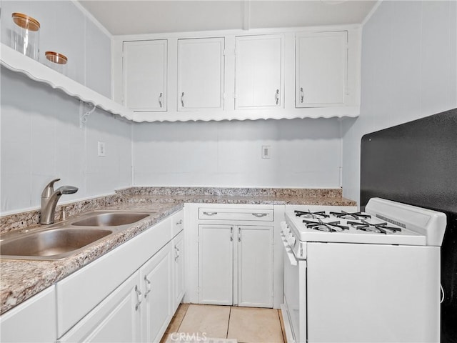 1040 Flora St, Barstow, CA 92311 - kitchen featuring white range with gas stovetop, a sink, white cabinetry, light countertops, and light tile patterned floors