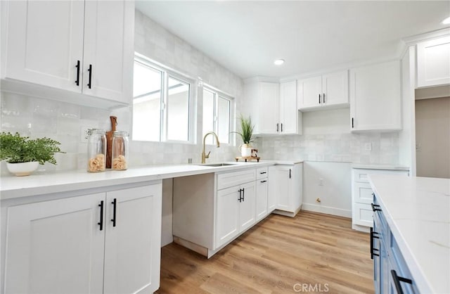 16417 Ivy Ave, Fontana, CA 92335 - kitchen featuring a sink, white cabinetry, decorative backsplash, light wood finished floors, and recessed lighting