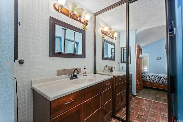 6919 Sandleford Way, San Diego, CA 92139 - ensuite bathroom with vanity, a textured ceiling, and tile walls