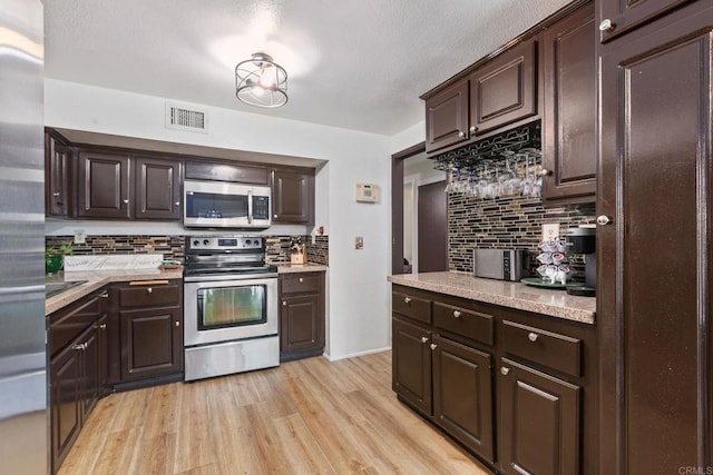 6919 Sandleford Way, San Diego, CA 92139 - kitchen with stainless steel appliances, tasteful backsplash, and dark brown cabinetry
