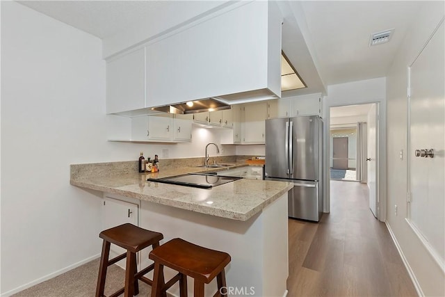 22789 Palm Ave Unit B, Grand Terrace, CA 92313 - kitchen with freestanding refrigerator, black electric stovetop, a sink, a peninsula, and a breakfast bar