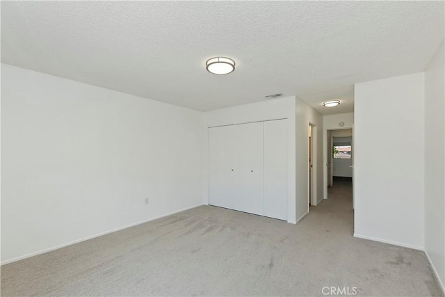 22789 Palm Ave Unit B, Grand Terrace, CA 92313 - unfurnished bedroom with light colored carpet, a closet, baseboards, and a textured ceiling