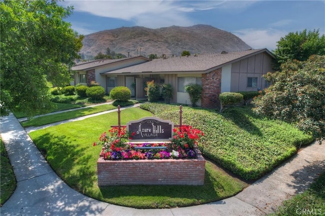 22789 Palm Ave Unit B, Grand Terrace, CA 92313 - view of front of property featuring board and batten siding, a front lawn, a mountain view, and brick siding