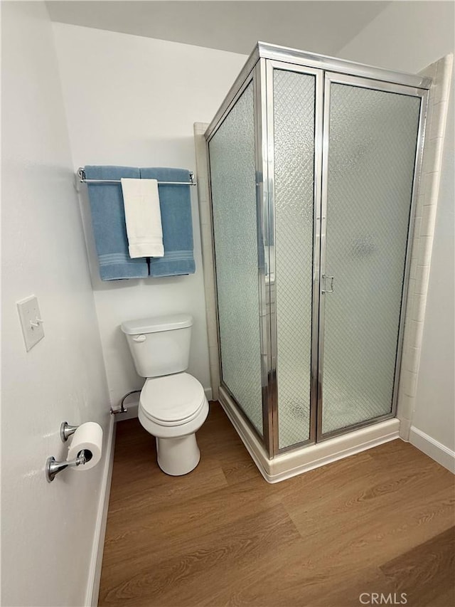 22789 Palm Ave Unit B, Grand Terrace, CA 92313 - bathroom featuring wood finished floors, baseboards, toilet, and a stall shower