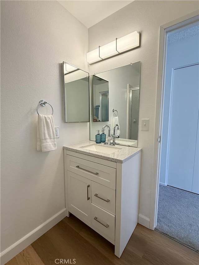 22789 Palm Ave Unit B, Grand Terrace, CA 92313 - full bathroom with wood finished floors, vanity, baseboards, and an enclosed shower
