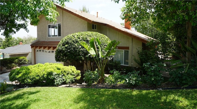 24530 Breckenridge Pl, Newhall, CA 91321 - view of home's exterior with a chimney, a garage, a lawn, and stucco siding