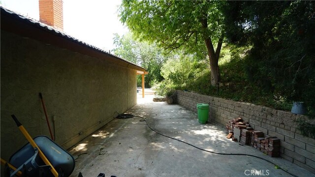 24530 Breckenridge Pl, Newhall, CA 91321 - view of side of home featuring a patio, a chimney, and stucco siding