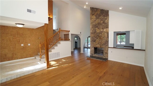 24530 Breckenridge Pl, Newhall, CA 91321 - unfurnished living room featuring stairs, wood finished floors, high vaulted ceiling, baseboards, and a stone fireplace