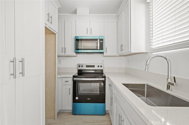 2101 W 76th St, Los Angeles, CA 90047 - kitchen with stainless steel appliances, a sink, light countertops, and white cabinets