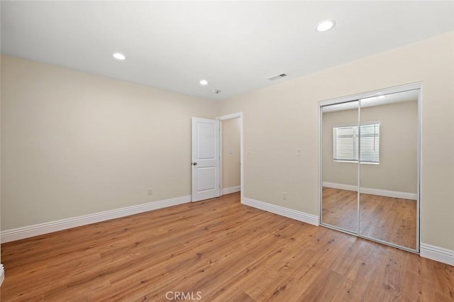 2101 W 76th St, Los Angeles, CA 90047 - unfurnished bedroom with light wood finished floors, a closet, baseboards, and recessed lighting