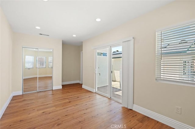 2101 W 76th St, Los Angeles, CA 90047 - unfurnished bedroom with access to exterior, multiple windows, light wood-type flooring, baseboards, and recessed lighting