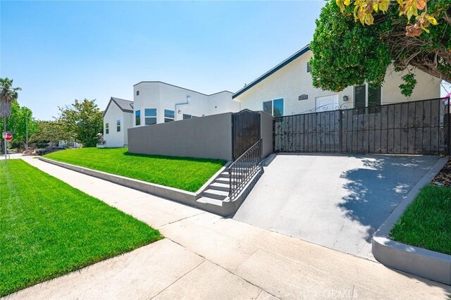 2101 W 76th St, Los Angeles, CA 90047 - view of side of home featuring a fenced front yard, stucco siding, and a gate